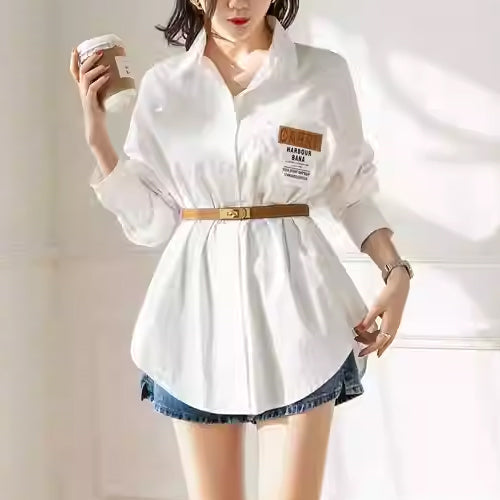 Slim tan belt styled over a white shirt with denim shorts